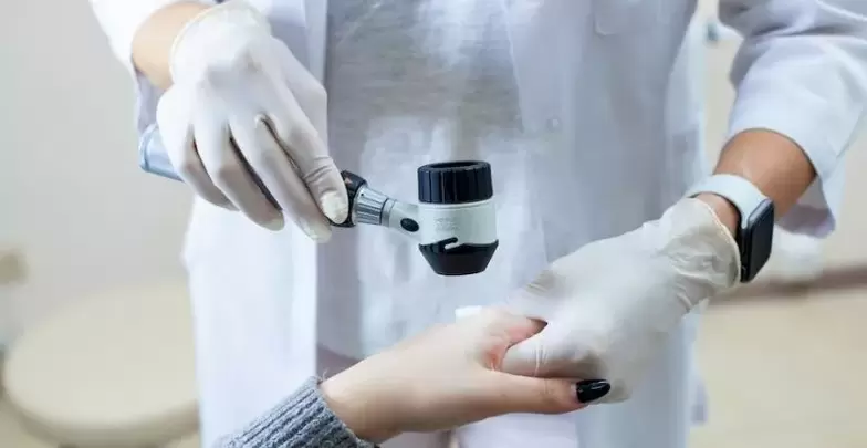 Pacjent z brodawkami w trakcie diagnostyki przez dermatologa